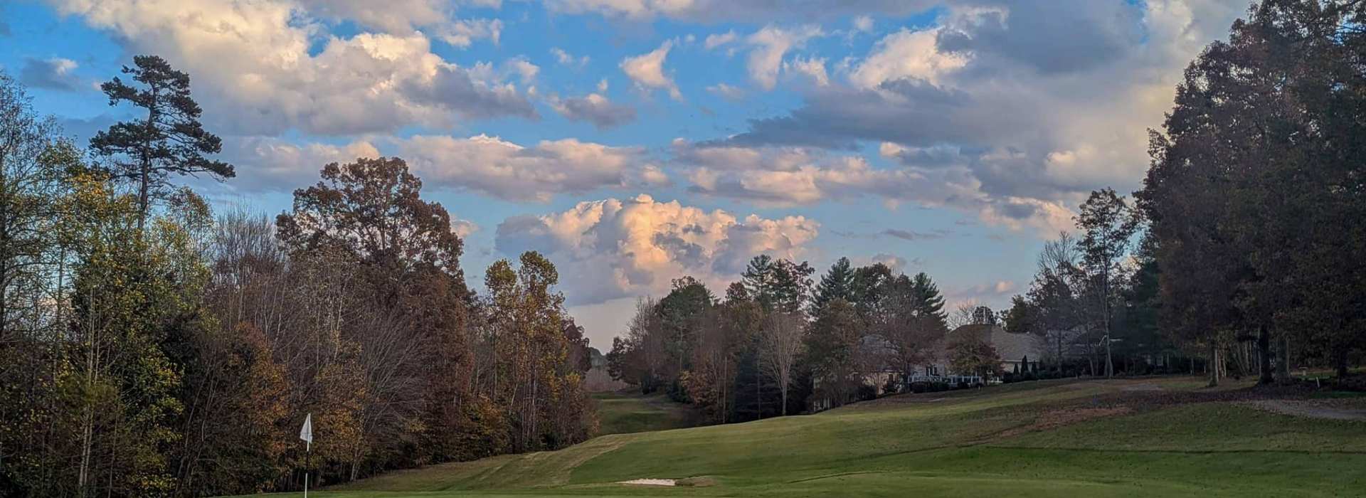 View of golf course beneath clouds in blue sky